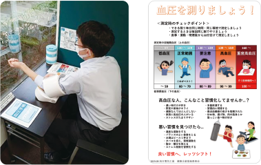 血圧を測る従業員の写真と促進のポスター